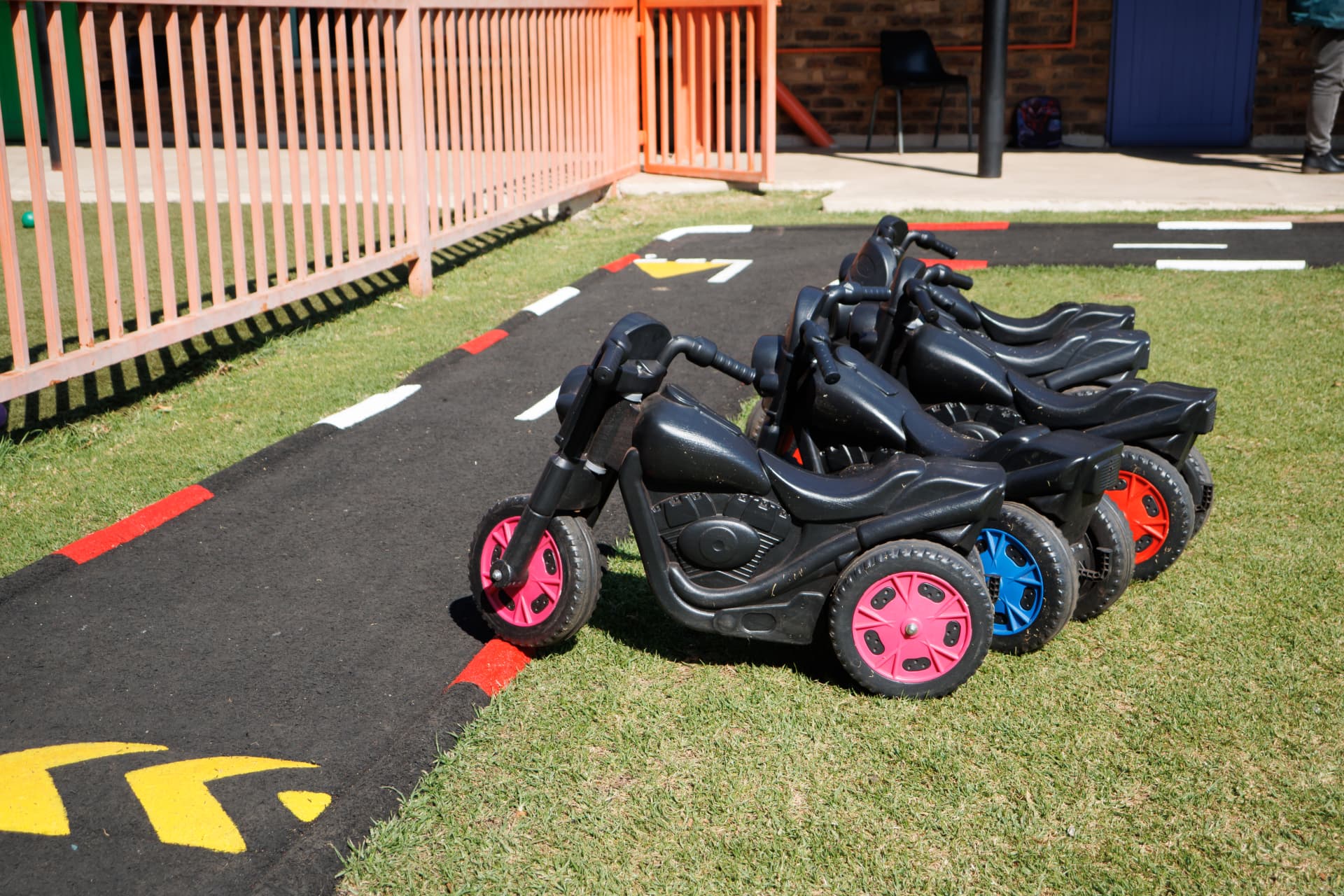 Ride-on bikes parked along the painted tarred track