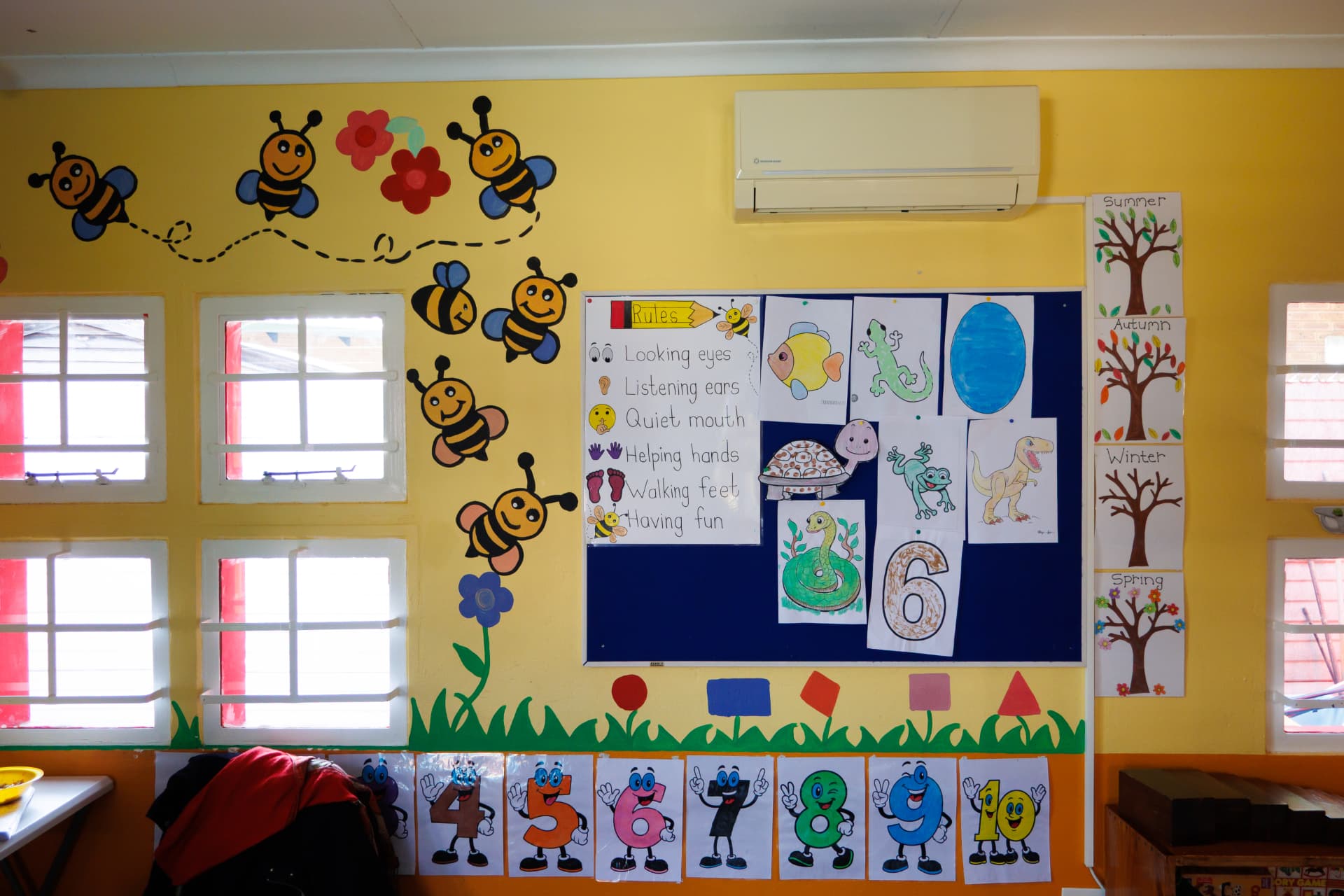 Classroom wall with painted bees, class rules and number posters
